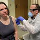 A pharmacist gives Jennifer Haller, left, the first shot in the first-stage safety study clinical trial of a potential vaccine for covid-19 on March 16, 2020, at the Kaiser Permanente Washington Health Research Institute in Seattle.
